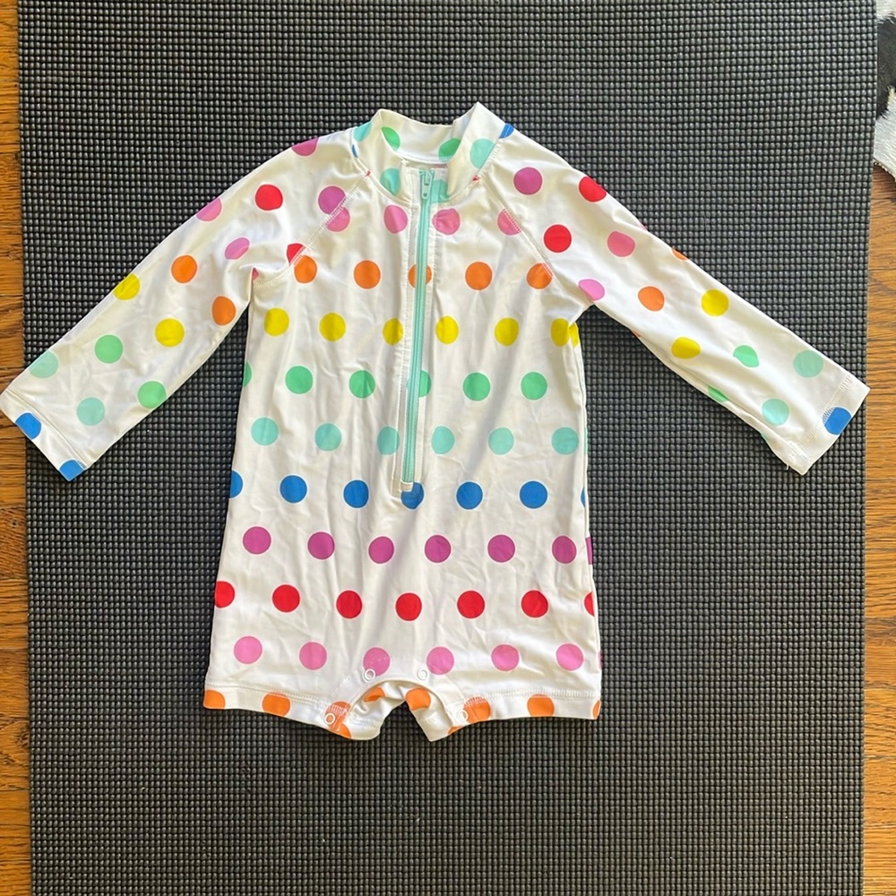Baby one-piece rash guard in rainbow dot.